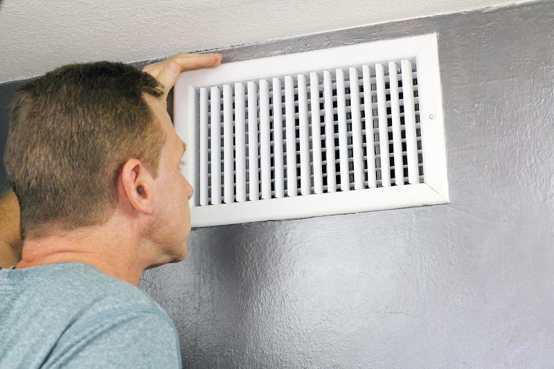 Man Looking at AC Vent