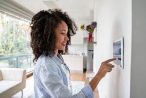 Woman Adjusting Smart Thermostat